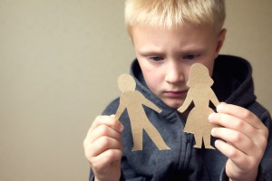 Confused child with cutting paper parents, family problems, divorce, custody battle, suffer concept