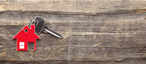 Symbol of the house with silver key on vintage wooden background